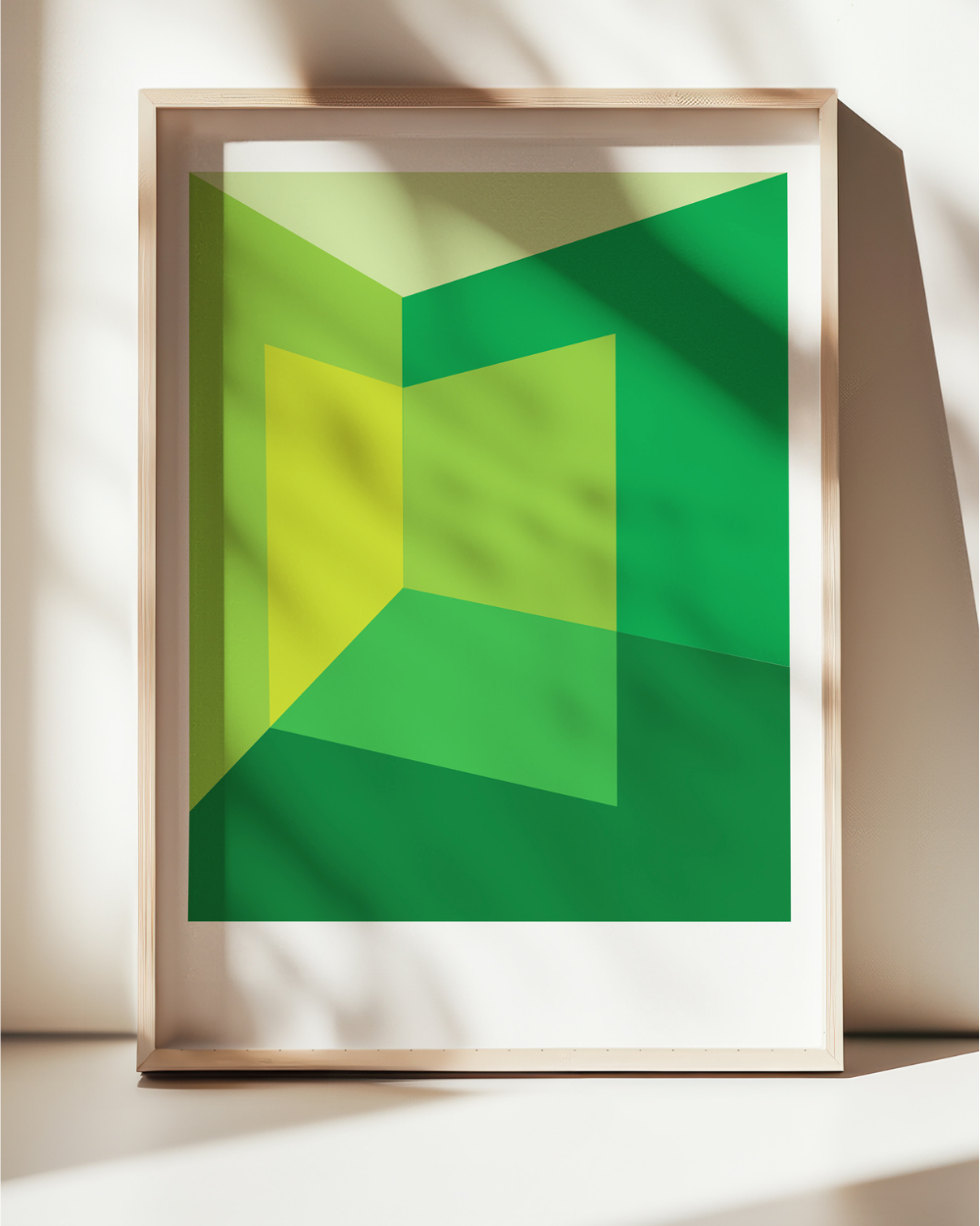 Framed abstract art with green and yellow geometric design on a light background