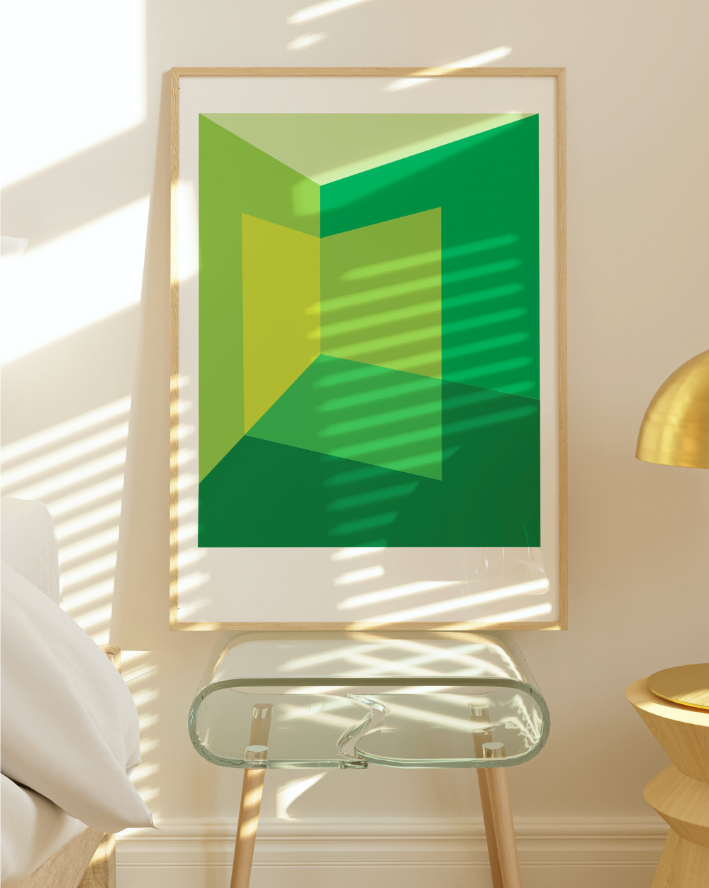 Framed abstract green artwork on a wall with natural light casting shadows.