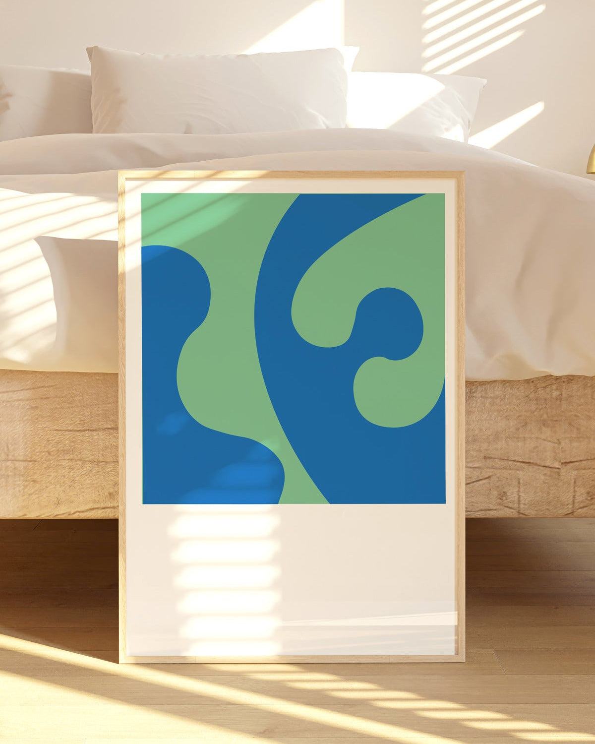 Framed abstract artwork with blue and green design on a wooden floor.