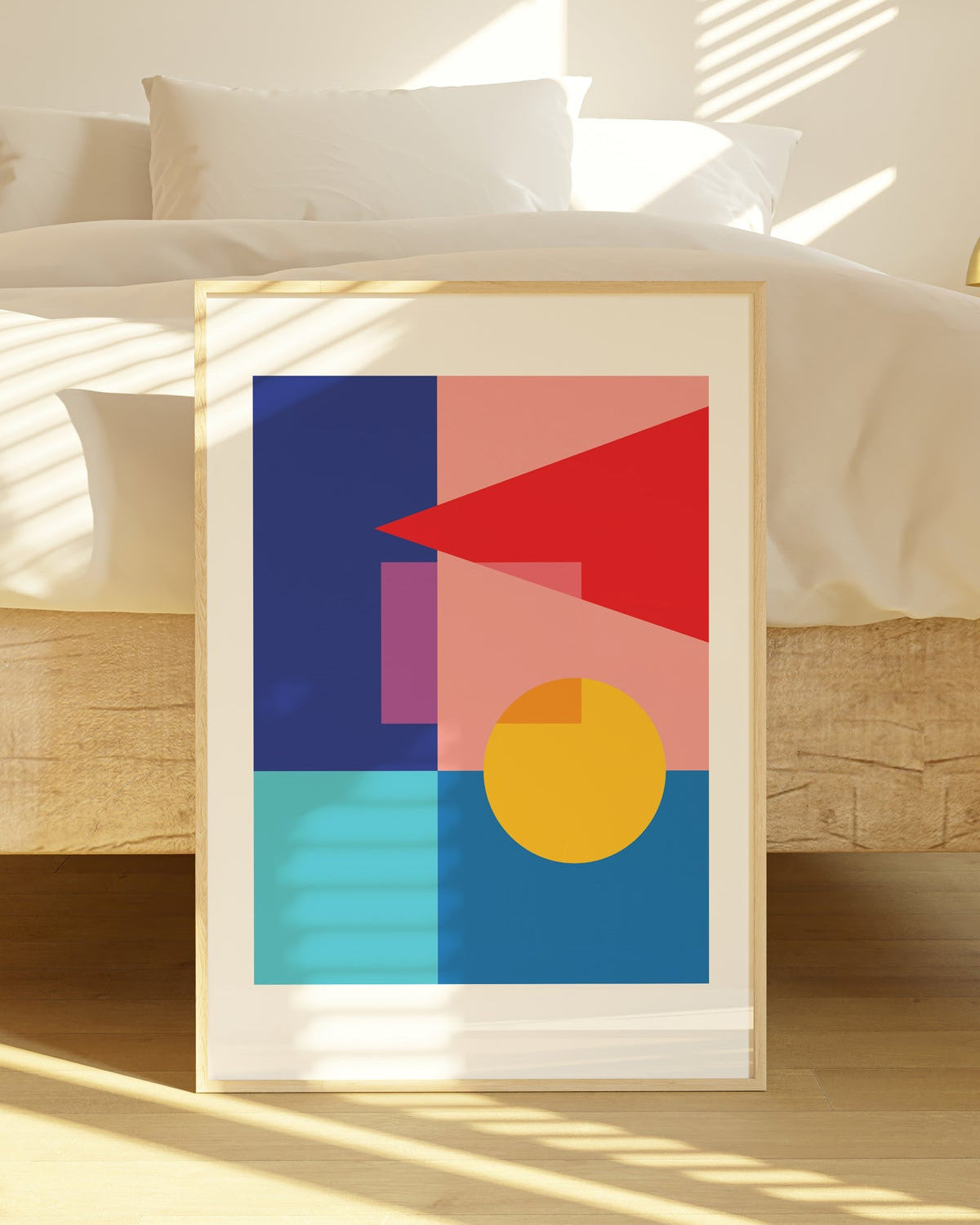 Framed abstract art print with geometric shapes on a wooden floor.
