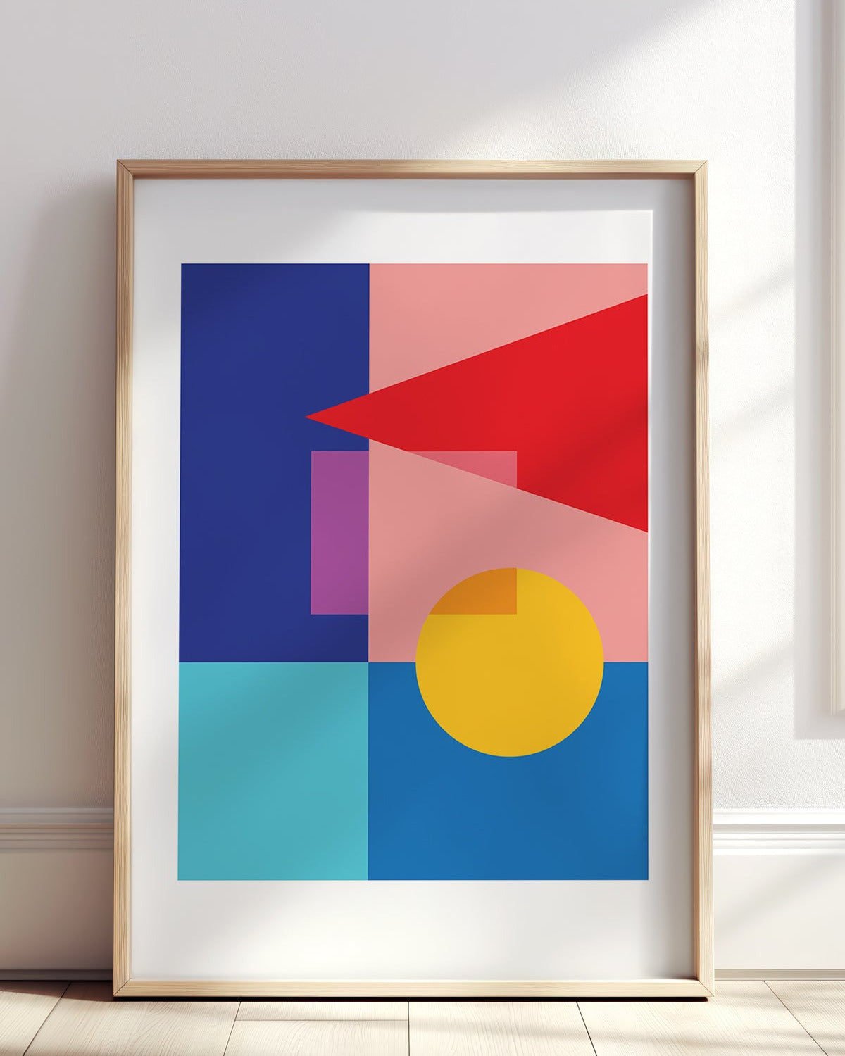 Framed abstract art print with geometric shapes on a white wall.