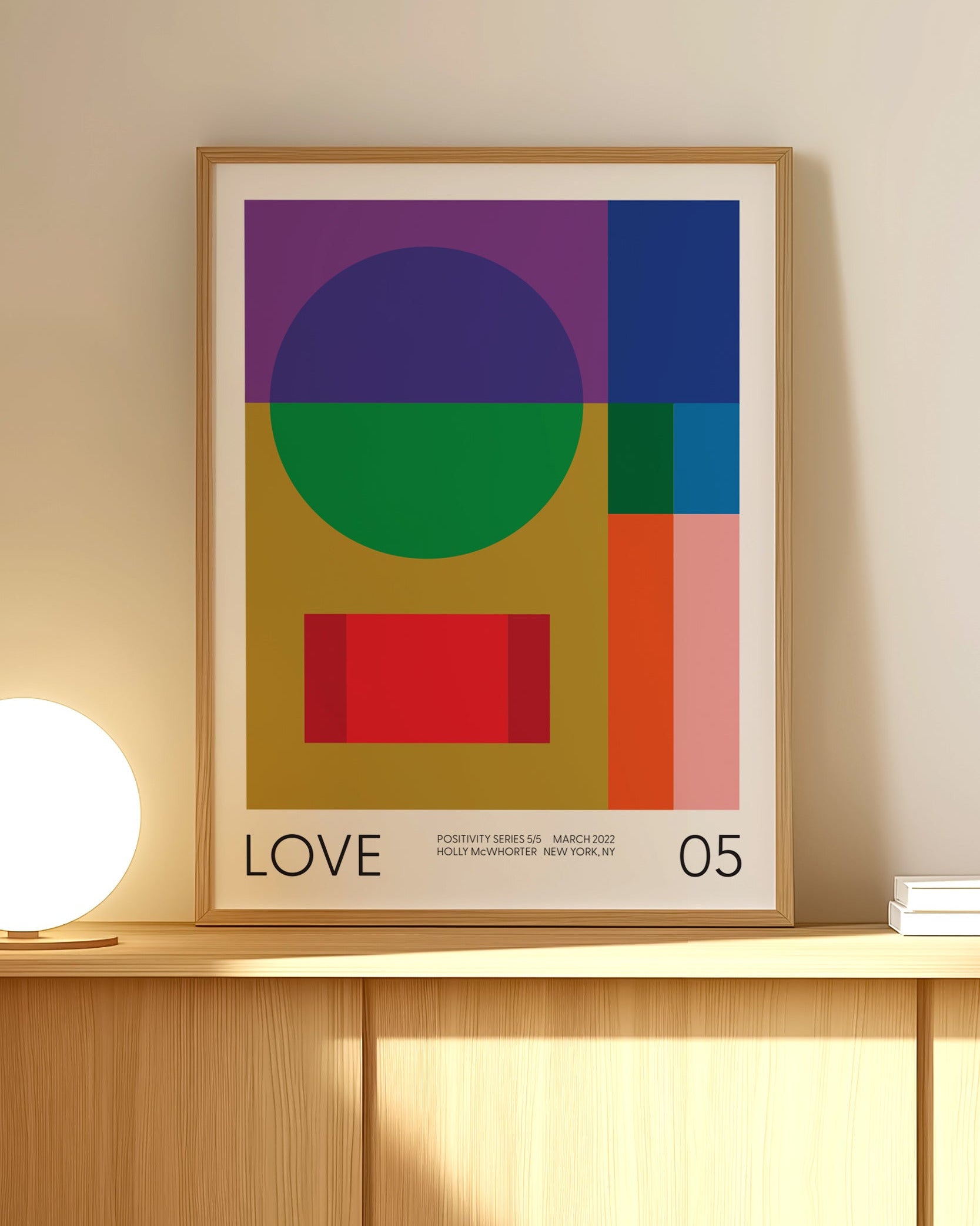 Framed abstract art print with geometric shapes on a wall
