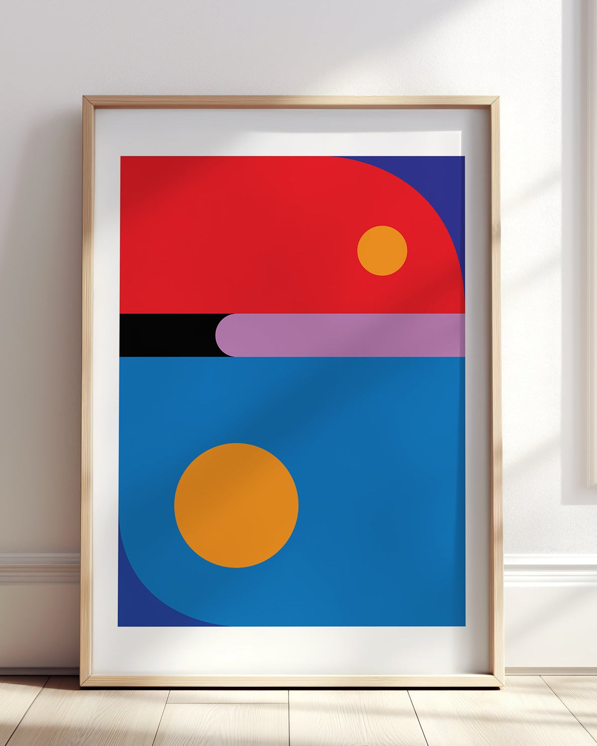 Framed abstract art print with geometric shapes on a white wall.