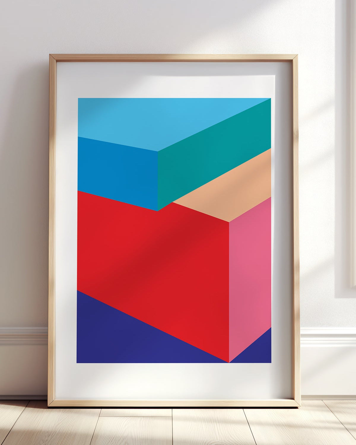 Framed abstract art print with geometric shapes in blue, red, and pink on a white wall.