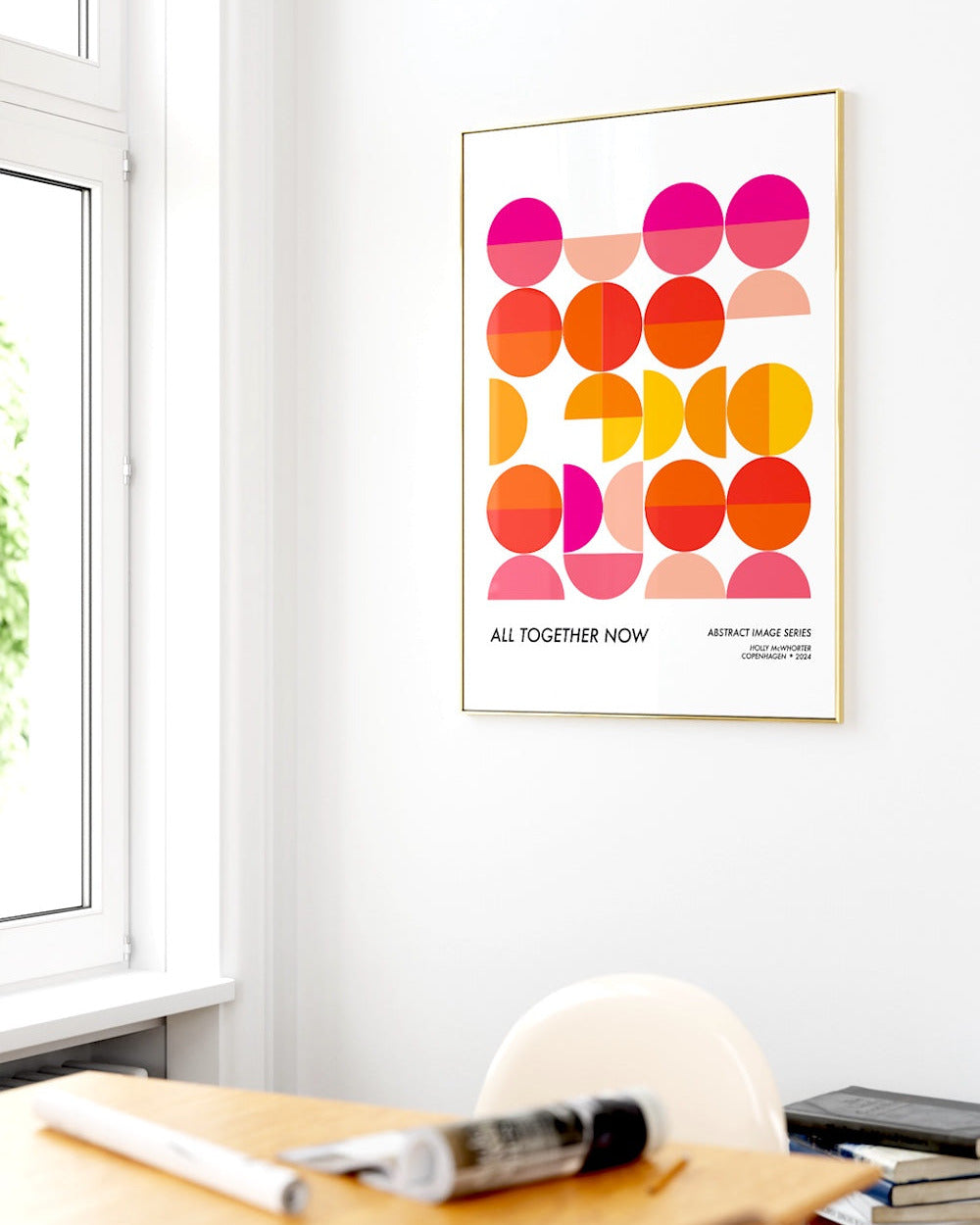 Colorful abstract art print on a wall in a room with a desk and window.