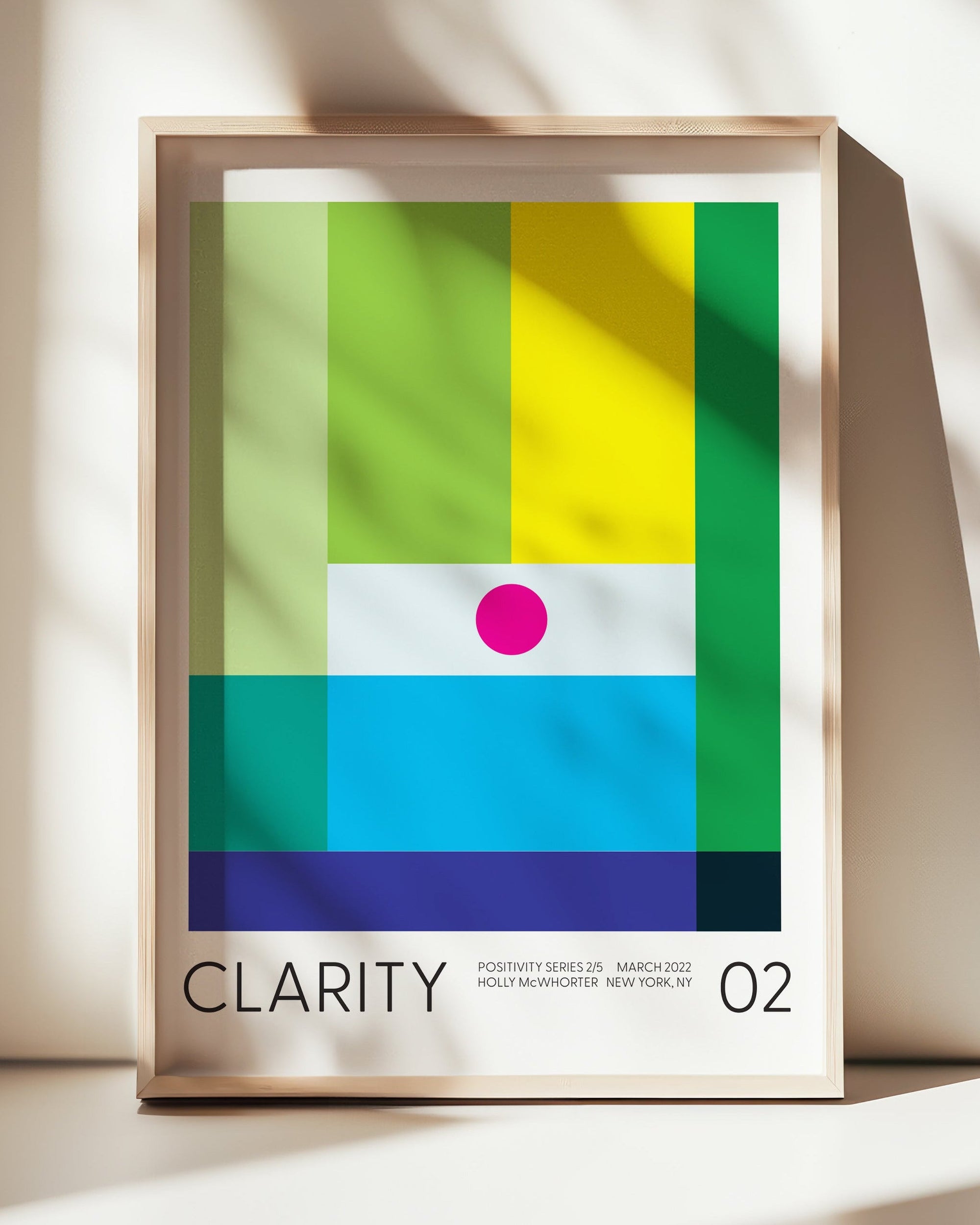 Framed abstract art print with colorful geometric design on a white surface.